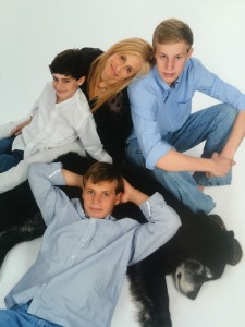 Amy and her ‘4 boys’: Carson (top left), 10, Grant, 15, and Braden, 18, reclining on top of George.
