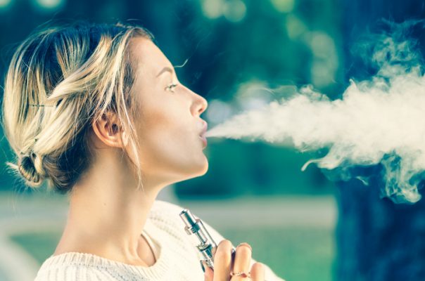 Teenage girl using electronic cigarette